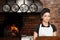 Woman Chef standing in the kitchen with wood oven
