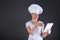 Woman chef with tablet over dark background