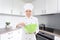 Woman in chef uniform mixing something in green plastic bowl in