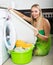 Woman cheking white clothes near washing machine