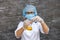 Woman chemist in protective uniform making experiment with blue and yellow flask