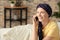 Woman after chemotherapy talking on mobile phone at home