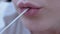 Woman Chews Chewing Gum Stretches it in Length with Fingers. Zoom. Close up