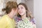 Woman and child with a bouquet of flowers in their house. Mother`s day