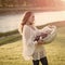 Woman with child in crib on sunny summer day