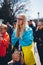 A woman with a child in the crowd wrapped in a Ukrainian flag.
