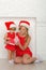 Woman with a child in Santa costumes look gift