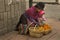 A woman with a child sells fruit on a street in Cuenca, Ecuador.