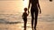 Woman with child standing in water on beach