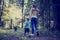 Woman and child walking a dog in the forest