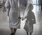 A woman with a child in white bathrobes walking in a spa center