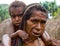 Woman with children Dani tribe sitting on the ground in the village.