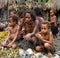 Woman with children Dani tribe sitting on the ground in the village.