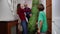 Woman with children open door to Christmas tree