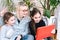 Woman with children sitting at home and holding videocall. Family using smartphone for video call with friend or family. People