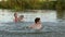 A woman with children are swimming in water outdoors