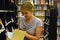 Woman chooses book in bookstore. Regiments with books in big library
