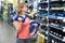 Woman chooses dumbbells for fitness in sports shop