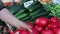 Woman chooses large fresh tomatoes on the market