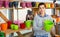 Woman chooses plastic flowerpot at garden store