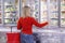 Woman chooses products in the freezing department in a supermarket. Healthy eating and lifestyle. Back view. Blurred
