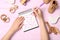 Woman choosing baby name at pink wooden table, top view