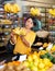 Woman choosing bananas in fruit and vegetable section of supermarket