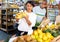 Woman choosing bananas in fruit and vegetable section of supermarket
