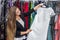 Woman choosing beautiful evening garment in dress store