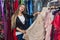 Woman choosing beautiful evening garment in dress store