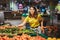 woman choosing cucumber from store shelf grocery shopping