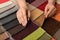 Woman choosing fabric among multicolored samples, closeup