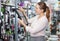 Woman is choosing grater for her kitchen in tableware shop