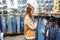 Woman choosing jeans in clothing store. teen girl buys jeans in the mall