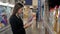 Woman choosing laundry detergent in grocery store. Businesswoman in supermarket