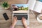 Woman choosing new house online using laptop or real estate agent working at table