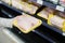 Woman choosing packed chicken meat in supermarket