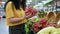 Woman choosing products at supermarket for cooking, healthy foods fruits, dragon fruit, supermarket.Young woman buys