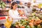 Woman choosing sweet pepper and man near choosing melon