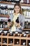 Woman Choosing Wine Bottles In Shop