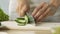 Woman chopping fresh cucumber cooking healthy salad for family dinner, close-up