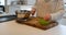 Woman chopping a vegetable with knife on kitchen worktop