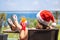 Woman in christmas santa claus hat and slippers relaxing and drinking cocktail on balÑony opposite palm trees beach and sea.