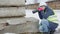 Woman civil engineer taking pictures of damaged construction concrete blocks