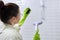 Woman cleaning in bathroom, washing glass with shower steam