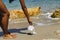 Woman cleaning the beach, picking up a covid face mask garbage