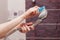 Woman cleaning an calcified shower head in domestic bathroom with small brush.