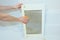 Woman is cleaning a capture panel of a kitchen hood, range hood, extractor hood from grease with a sponge and a detergent