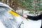 Woman cleaning car from snow with brush. Transportation, winter,