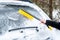 Woman cleaning car from snow with brush. Transportation, winter,